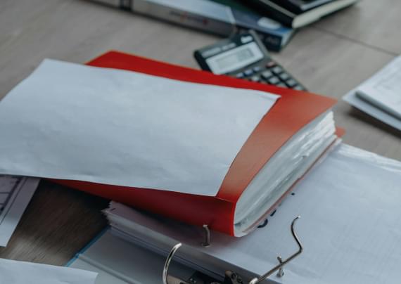 Day To Day Tax & Investments LLC tax preparation documents and financial records in red binder with calculator, Orlando Florida bookkeeping and credit repair services